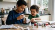 © Николай Срибяник - Young brothers collaborate on science project building model rocket at home kitchen table.