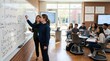 © Николай Срибяник - Diverse female teacher guiding student solving calculus equations at whiteboard with classmates using laptops in modern classroom.