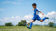 © Y Creative Stock - サッカーをする小学生の男の子 芝生のグラウンド コピースペース