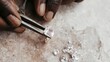 © Viktoriia - Artisan using tweezers to examine sparkling gems on marble surface