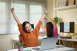 © Stella 16 - Young woman business colleagues or employee do exercise at work in office or taking a break. Relaxing and stretching hands after long hours of work. Stress relief in workplace
