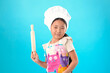 © Midea  - Young girl cook in chef hat holding rolling pin on turquoise background