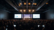 © Hub - Audience members sitting in a dark auditorium watching a professional presentation at an innovation symposium conference event with large projection screens