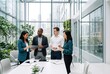 © AdPremium - Diverse group of business professionals collaborating and discussing a project using a digital tablet in a modern, bright office