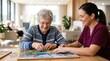 © iravgustin - Active senior focused on solving a jigsaw puzzle while a professional caregiver offers support, representing cognitive activity, brain health, and senior leisure integration.
