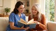 © 5 Grace Media - Smiling caregiver and senior woman enjoying reading a book together at home.