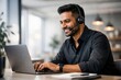 © Rawpixel.com - Smiling man using laptop headset.