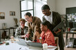 © AnnaStills - Diverse young adult team collaborating around laptop, reviewing project ideas and sharing feedback in office. Ideal for workplace teamwork, startup culture, innovation marketing