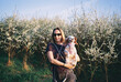 © Asya Molochkova/Stocksy - Woman Holding Cavalier Spaniel Near Blooming Trees