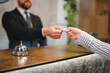 © Serhii - Hotel guest receiving key card at reception desk