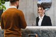 © Serhii - Hotel receptionist assisting guest with check in service