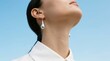 © Jiwa_Visual - Woman in white shirt, blue earrings against sky background
