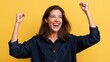 © AZ Studio - Woman in denim shirt celebrates with raised fists and joyful expression