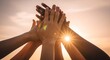 © TRI WAHYUNI - Diverse group of people stacking hands together against golden sunset sky