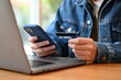 © Peterson - Person using phone and credit card for online shopping