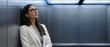 © 5 Grace Media - Thoughtful businesswoman in elevator looking up, contemplating her next career move.