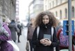 © Cavan Images - Young student with curly hair smiles on a city street