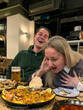 © Ina - Couple enjoying traditional Spanish paella in restaurant during vacation. Travelers sharing local cuisine, dining experience and conversation while exploring Spanish food culture.