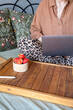 © Ina - Woman using laptop while sitting comfortably in bed with strawberries and notebook nearby. Remote work, freelance activity, online communication and flexible home office lifestyle concept.