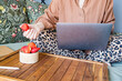 © Ina - Woman using laptop while sitting comfortably in bed with strawberries and notebook nearby. Remote work, freelance activity, online communication and flexible home office lifestyle concept.