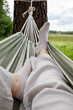 © Ina - First person view from hammock overlooking green countryside landscape. Relaxing outdoor getaway, peaceful leisure activity and slow living lifestyle surrounded by nature.
