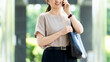 © Trickster* - 屋外でスマートフォンで通話する女性・ビジネスウーマン, Businesswoman Talking on a Smartphone Outdoors