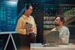 © Zamrznuti tonovi - It professionals discussing data center performance metrics on screen, ensuring network security and cloud infrastructure maintenance