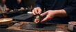© Shompa - Sushi chef rolling fresh tuna hand roll with seaweed and rice at traditional japanese restaurant counter with customers behind