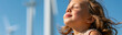 © Olga Ко - Long Panoramic banner of a peaceful little girl breathing fresh air with blurred wind turbines in the background, concept of clean renewable energy and sustainable future