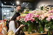 © LIGHTFIELD STUDIOS - A couple works together, arranging vibrant flowers in their cozy florist shop, showcasing teamwork.