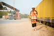 © offsuperphoto - Female worker in a safety uniform, talking on walkie talkie in a logistics yard