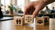 © Pro Team - Human hand choosing a wooden block with a balance scale icon representing justice and equality in professional business environments