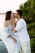 © Тарас Белецкий - Romantic couple sharing a tender kiss by the water at sunset