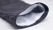 © KaTone - A rolled-up surf shirt revealing its technical fabric interior on a plain surface.