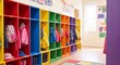 © Jana - A row of vibrant red blue and yellow cubbies with hanging backpacks and jackets inside a cheerful well lit kindergarten corridor