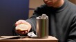 © Aliaksandr - Person showing a piece of bread, experiencing poverty and hunger, with a metal can containing money and coins on cardboard, symbolizing hardship, begging, and the need for charity and help
