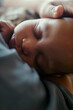 © DragonImages - Vertical shot of infant sleeping against mother while hand resting on head, conveying maternal care and bonding. Useful for parenting, maternity leave, childcare, family support campaigns