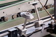 © Констянтин Батыльчук - Detailed view of circular guide discs mounted on a steel rail with manual adjustment levers on a manufacturing machine line.