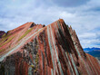 © Martin - Stunning Rainbow Mountain in Peru with a hiker standing on the peak under a cloudy sky