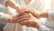 © Abu - Close-up of diverse hands stacked together symbolizing unity and support.