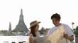 © blueringmedia - Young Asian Couple Reading Map with Wat Arun Temple Background