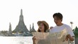 © blueringmedia - Young Asian Couple Holding Map with Wat Arun Temple Background