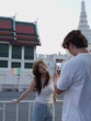 © blueringmedia - Young Man Taking Smartphone Photo of Smiling Woman by Temple