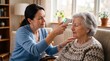 © tangmo.pa - Caregiver measuring senior woman's temperature with infrared thermometer.