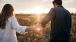 © Eko - Romantic young couple holding hands walking together in nature field during beautiful sunset, back view, love and relationship concept.