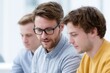 © Chandlerlikes - Business mentor guiding young startup founders during coaching session, contemporary office environment