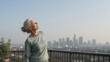 © Neural Canvas - Senior woman balcony city sunrise wellness, active lifestyle stretching exercise outdoor morning calm breathing, serene healthy retirement urban view