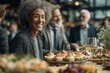 © Alexei - African American woman with curly hair smiles at a social gathering, elegantly dressed, surrounded by guests and a table filled with gourmet appetizers and drinks
