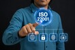 © Meea - Businessman interacting with holographic iso 27001 security icons and global network