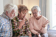 © luciano - Adult daughter meeting with senior parents, discussing financial planning, insurance, and retirement documents, offering support and advice at home